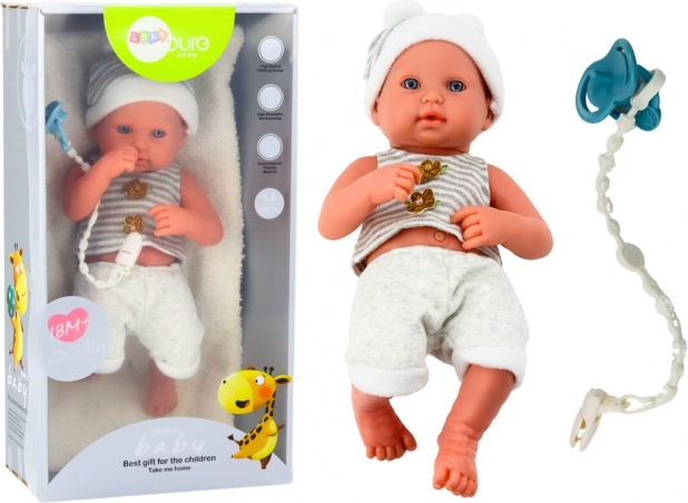 Realistična beba lutka u bijelo‑sivom outfitu s vrpcom za dudu i dekicom