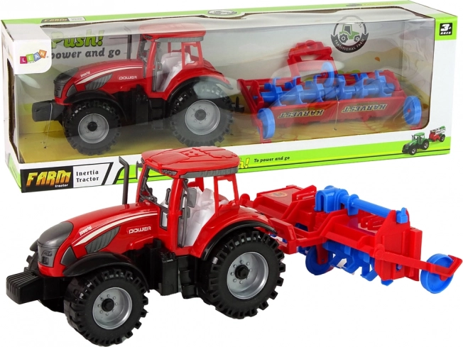 Crveni traktor s plugom s trenjnim pogonom
