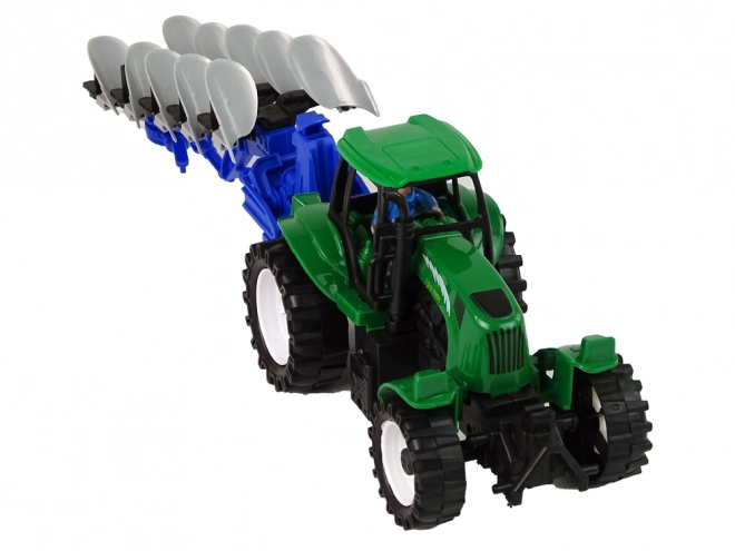 Zeleni poljoprivredni traktor s plugom