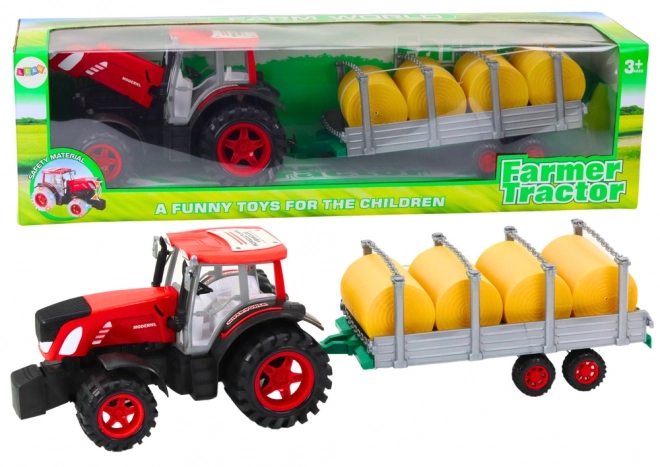 Veliki traktor s prikolicom i balama sijena