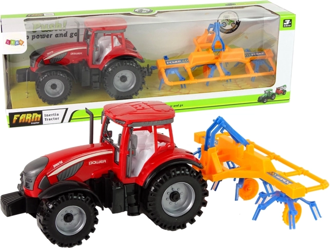Crveni traktor s grabljačem s frikcijskim pogonom