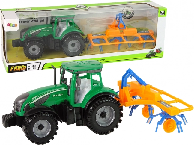 Zeleni traktor s grabljama s trenjnim pogonom
